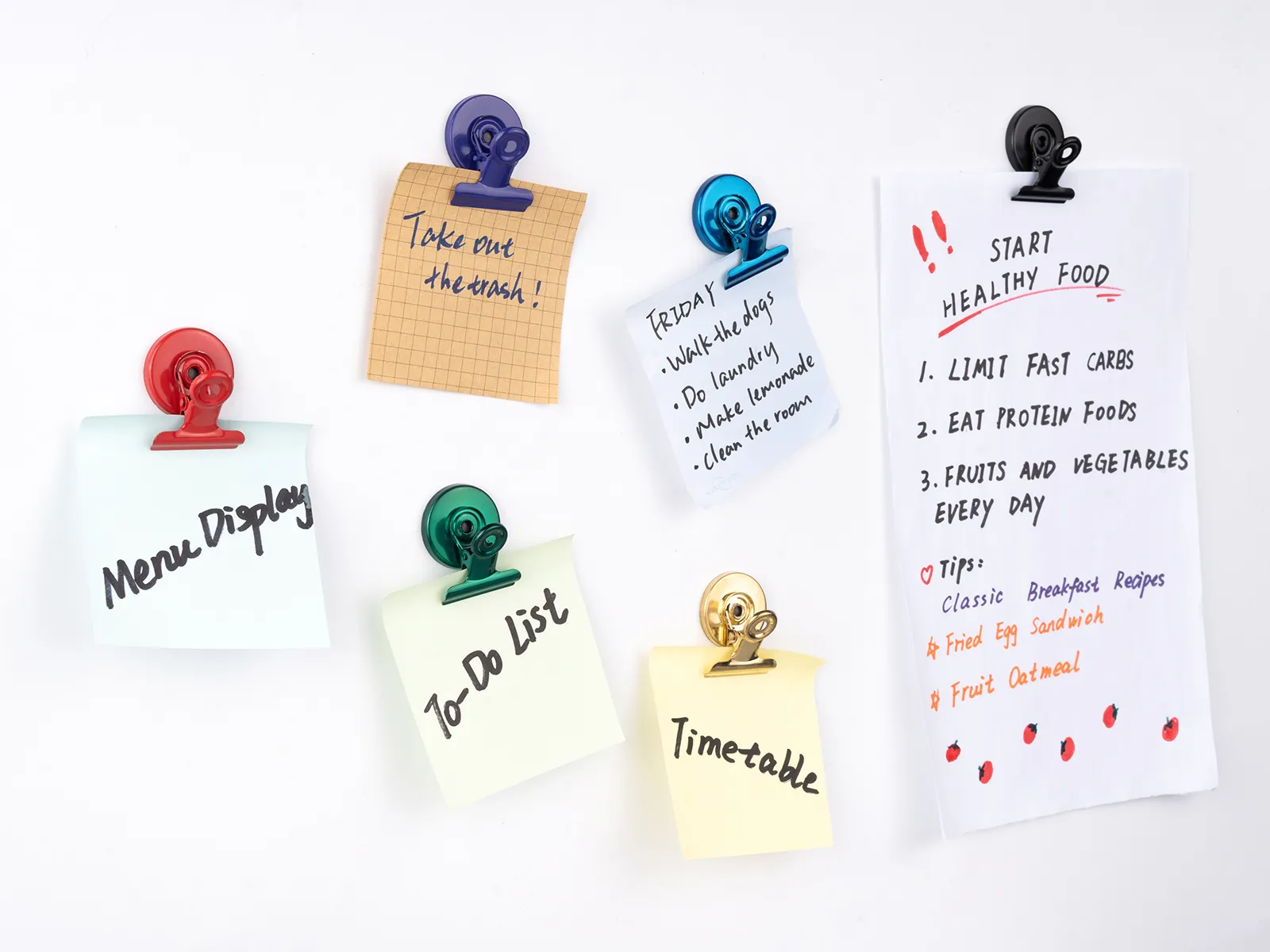 Colorful round magnetic clips holding notes on a white magnetic surface